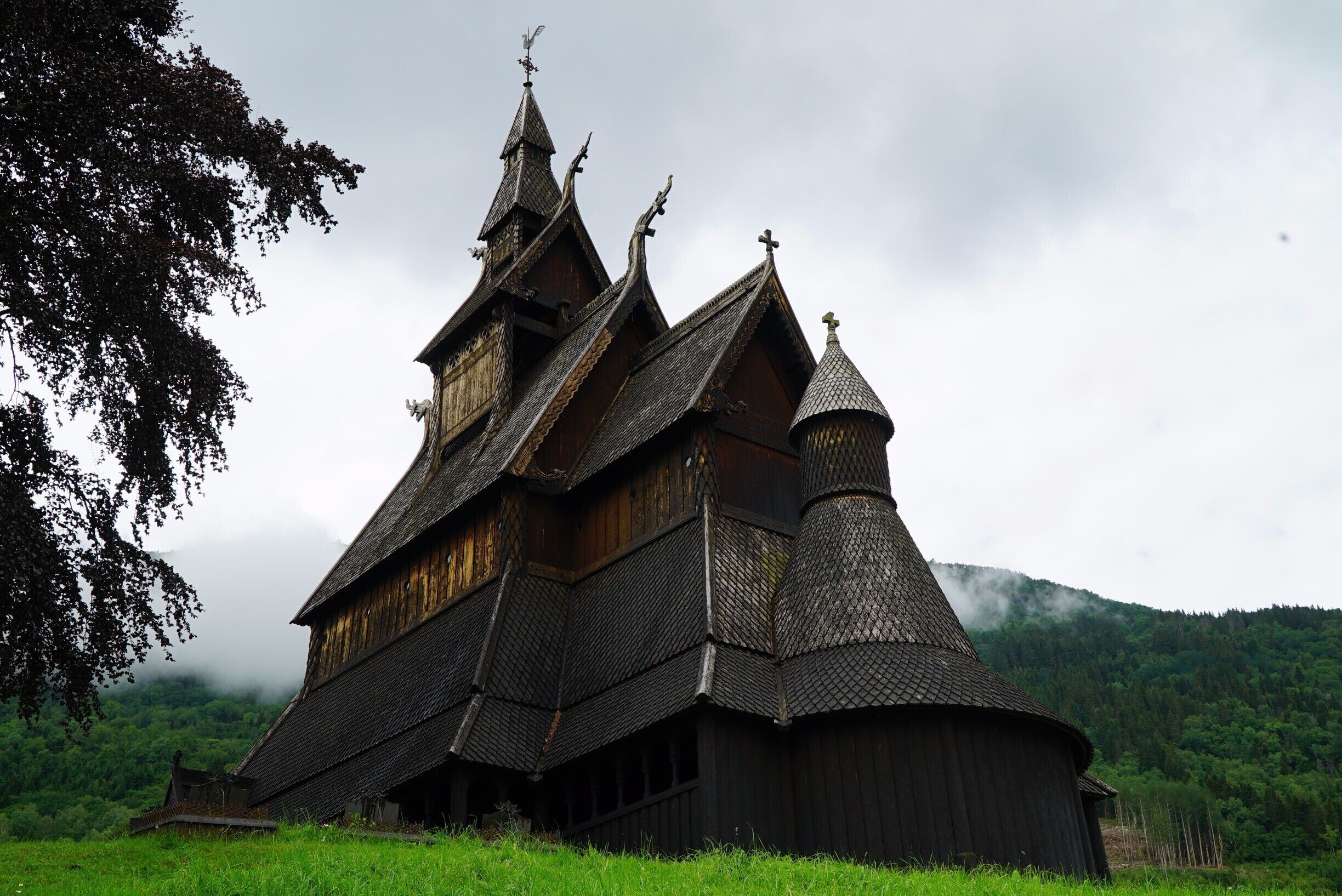 A traditional wooden church with steeply pitched roofs and a bell tower.