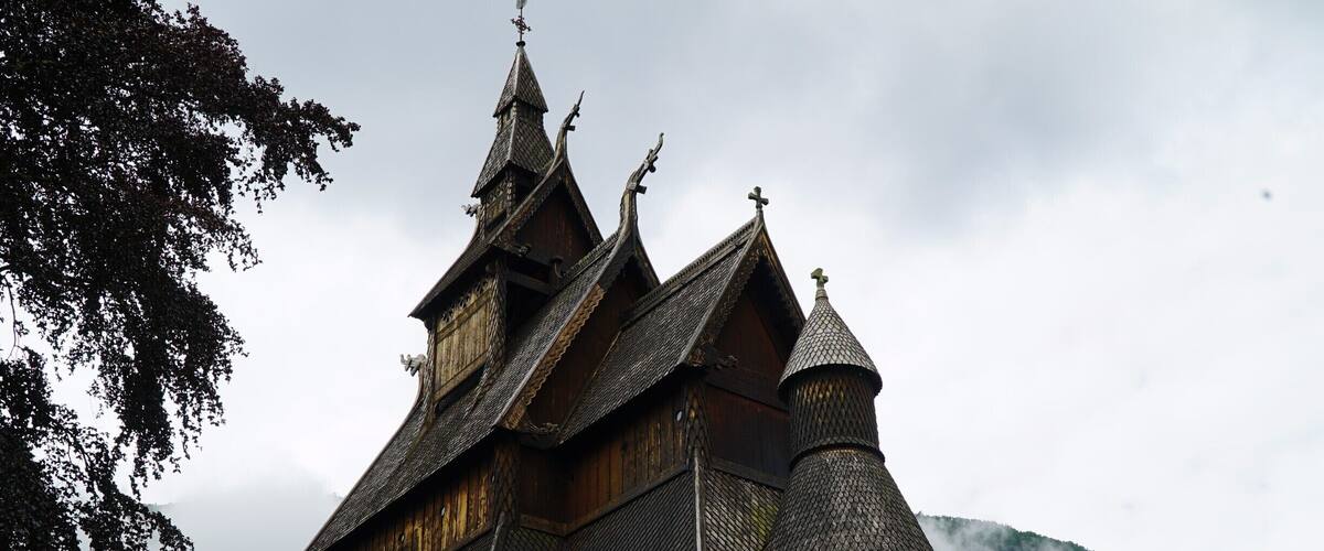 A traditional wooden church with steeply pitched roofs and a bell tower.