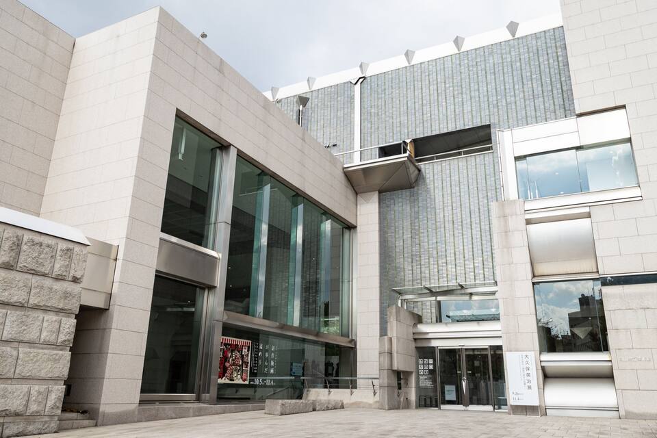 A modern building with large glass windows and a stone facade.