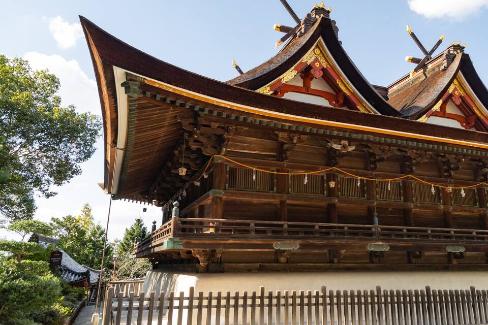 A traditional wooden building with ornate, curved roofs and golden decorations.