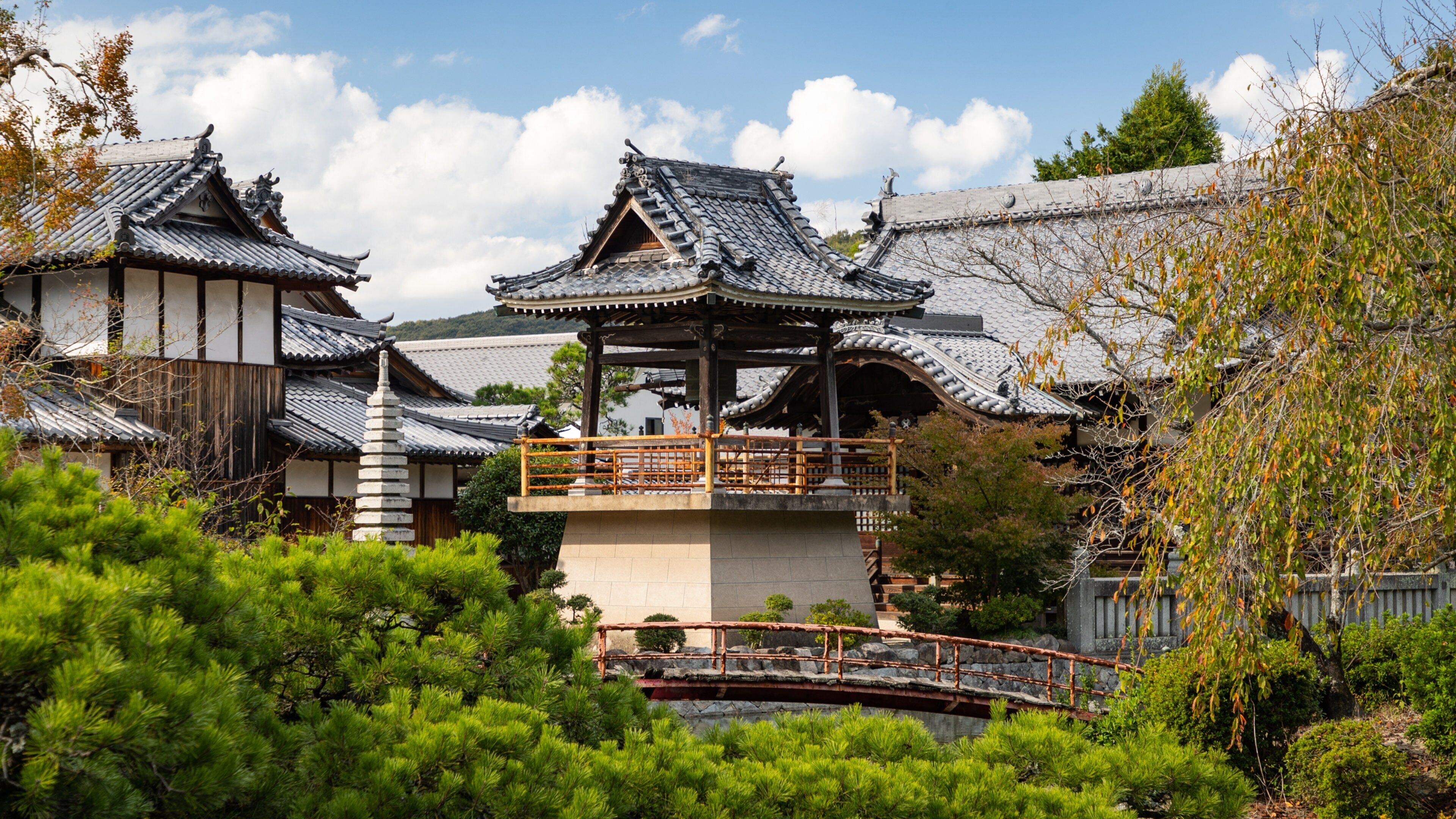 Traditional Japanese architecture with multiple buildings featuring tiled roofs and wooden structures.