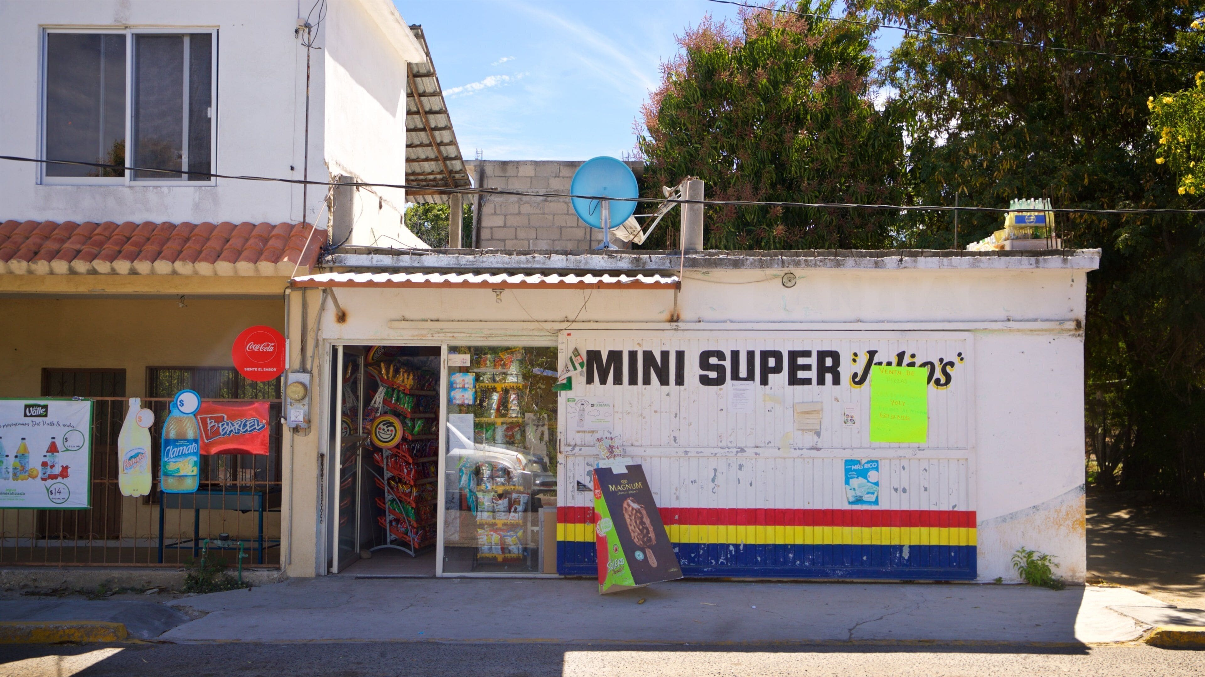 A storefront with a colorful sign and various advertisements.