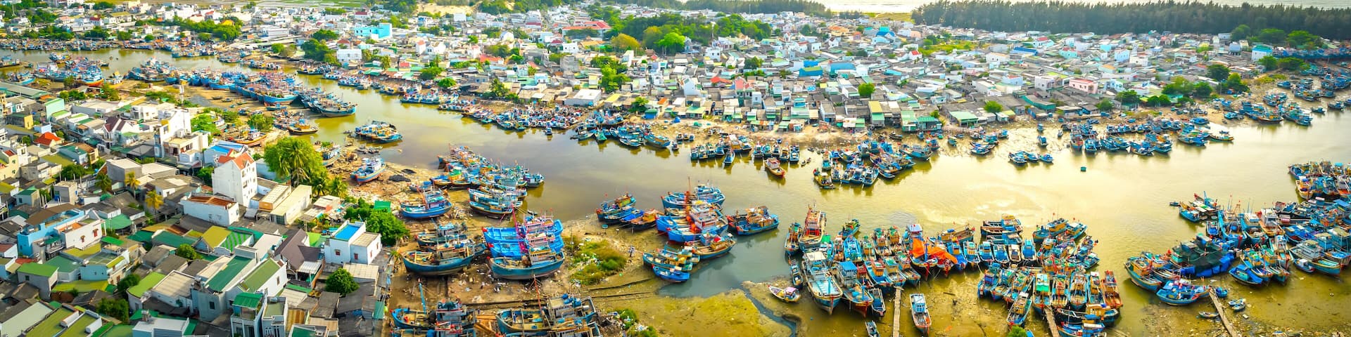 La Gi fishing village seen from above with hundreds of boats anchored along both sides of river to avoid storms near estuary, this is also a large fishing port providing seafood in central Vietnam