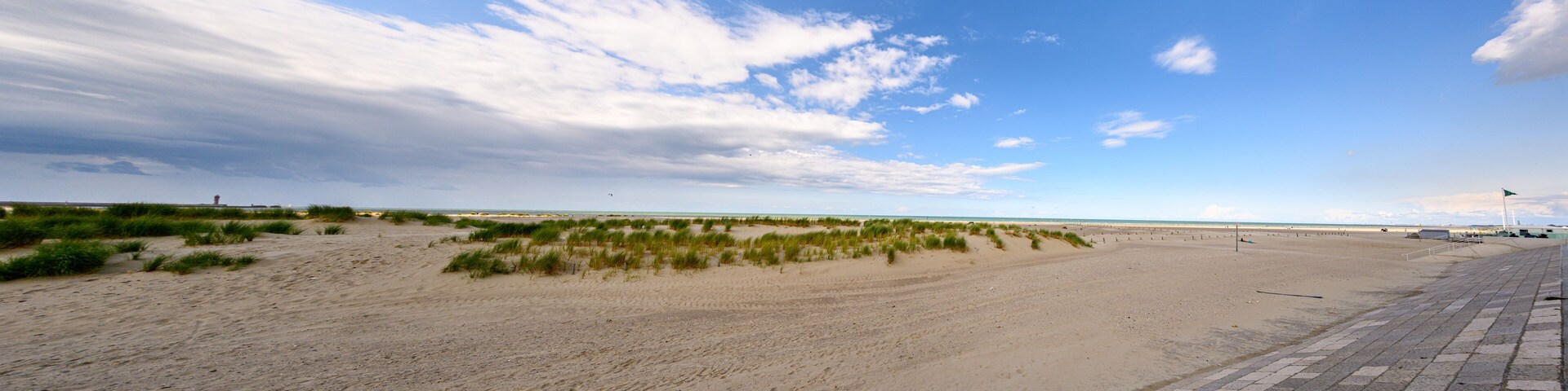 A beach with sand dunes and a clear sky.