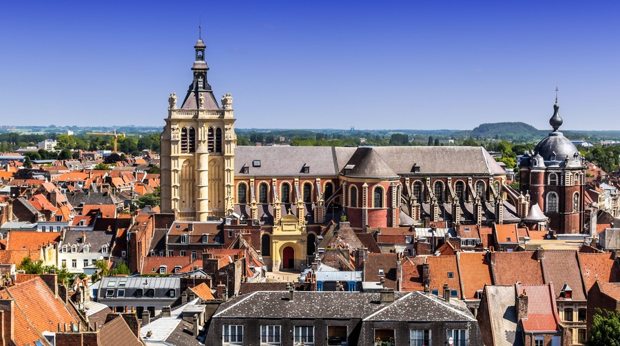 Un pueblo histórico con una iglesia destacada que presenta una alta torre campanario y una cúpula.
