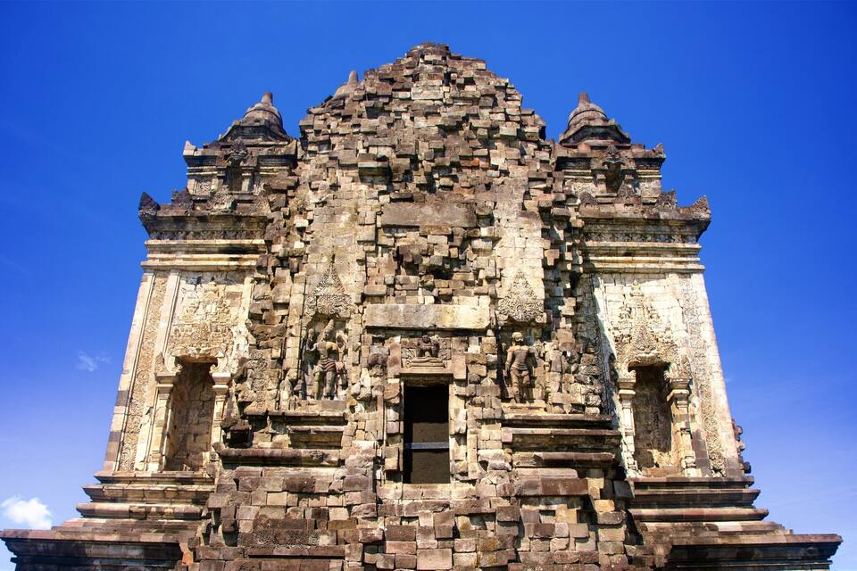 Um templo antigo com esculturas detalhadas e uma porta central.