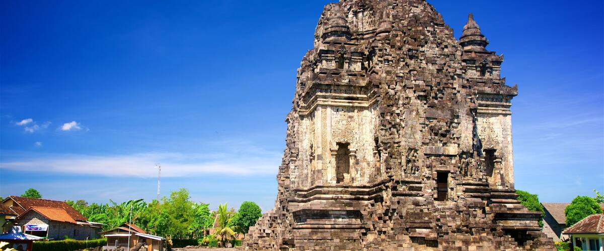 A large, ancient stone temple with intricate carvings and a prominent central tower.