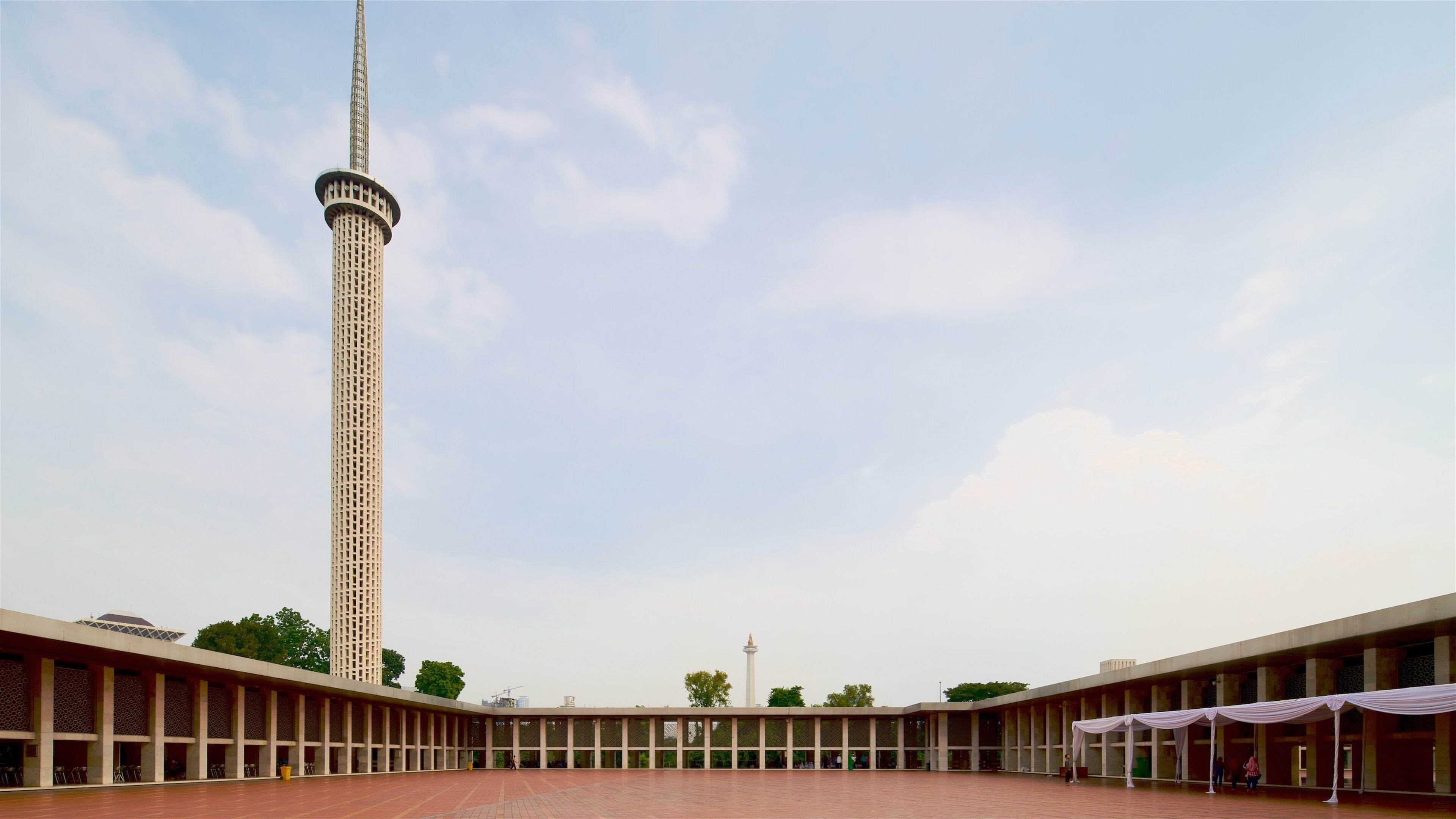 A tall tower with a lattice design, a covered walkway, and a clear sky.