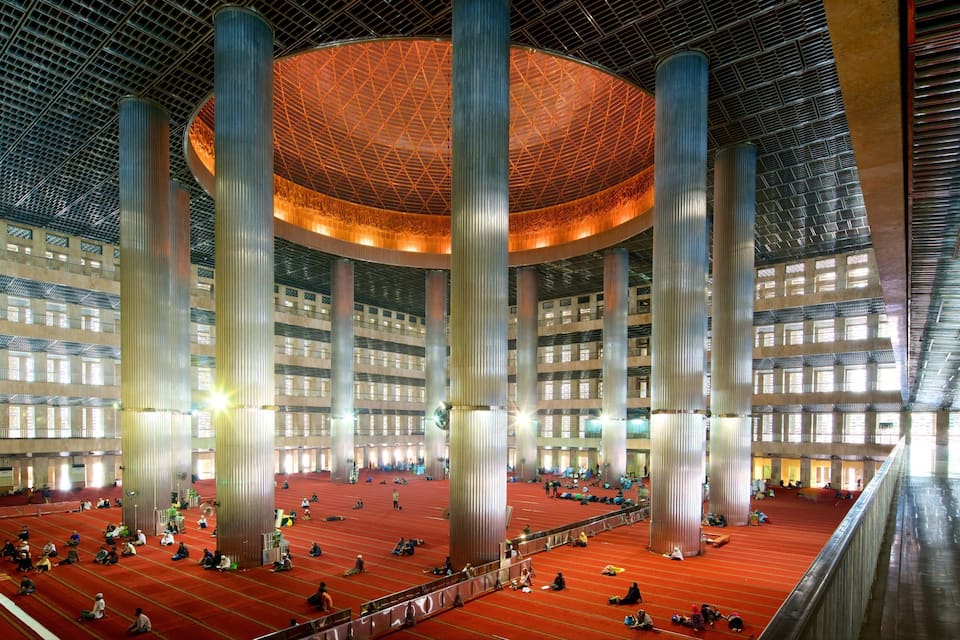 A large indoor space with high ceilings, large columns, and a patterned ceiling.