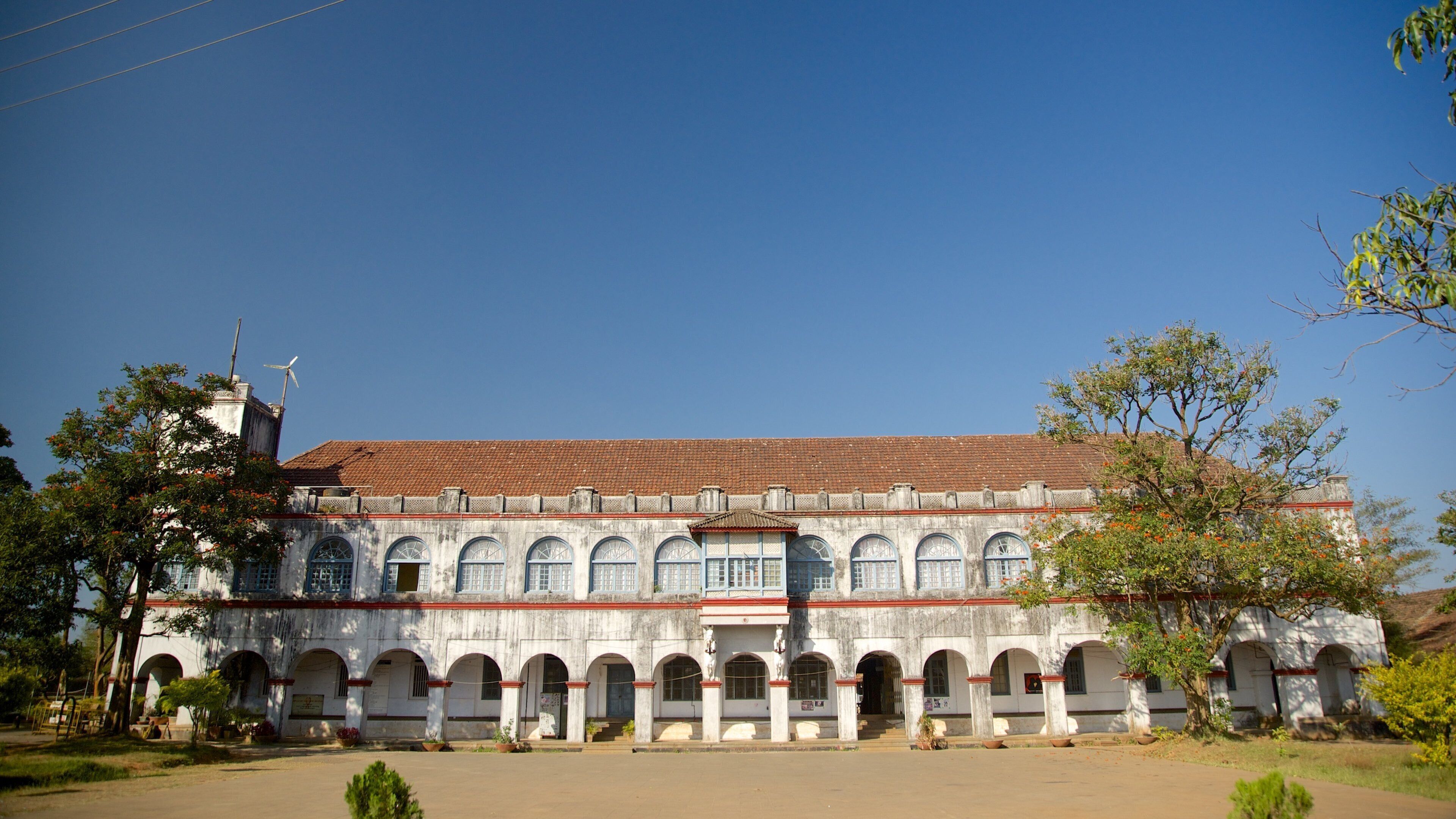 A large, historic building with a tiled roof and multiple arched windows.