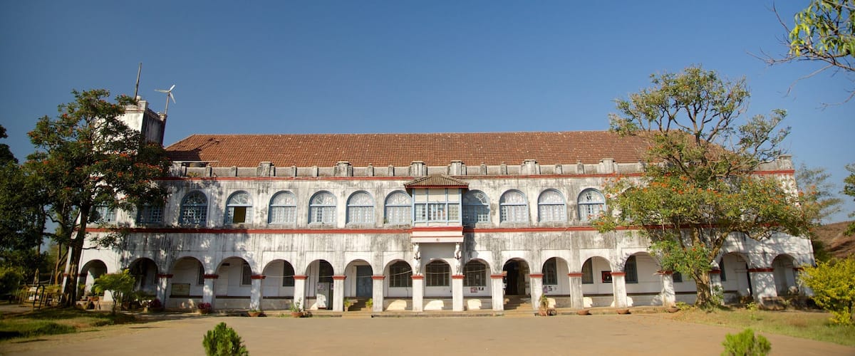 A large, historic building with a tiled roof and multiple arched windows.