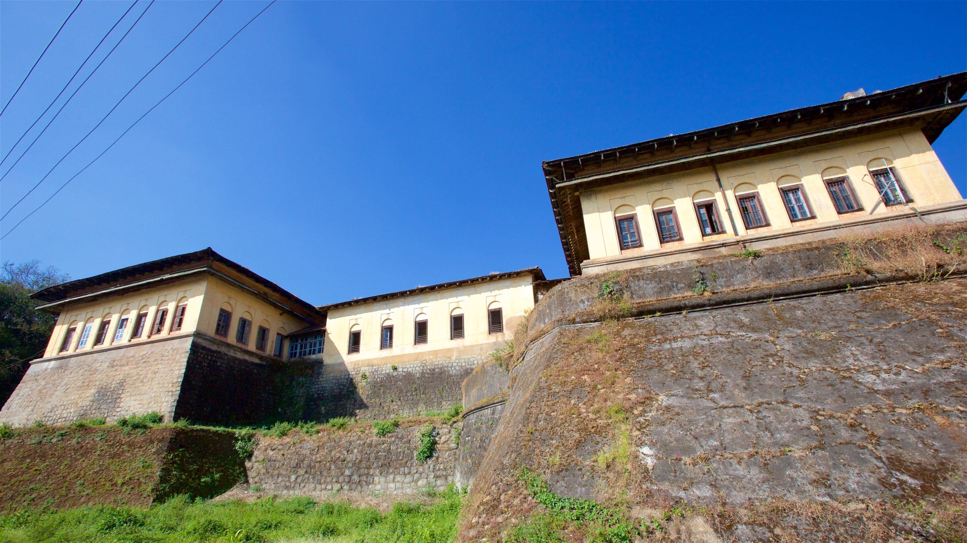 A historic building with arched windows and a stone wall.