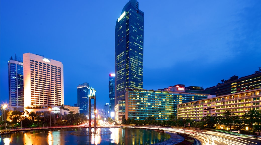 Bundaran HI ofreciendo escenas nocturnas, una ciudad y un rascacielos