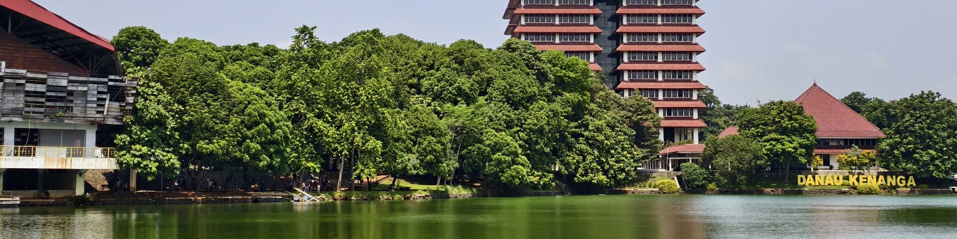 reflection of building on Kenanga Lake. Rectorate Building of the University of Indonesia. with trees, blue sky and clouds