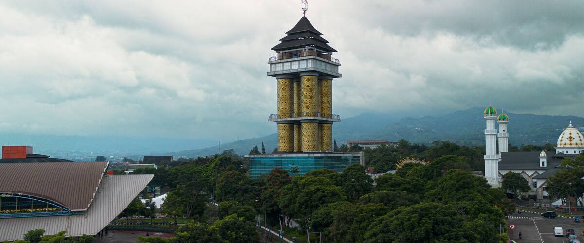 A stunning aerial drone photo of the mosque in Sabilulungan Building, Soreang, Bandung, Indonesia, showcasing its beautiful architecture, grand dome, and surrounding urban landscape