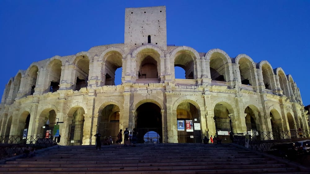 Ein historisches Amphitheater mit mehreren Bögen und einem zentralen Turm.