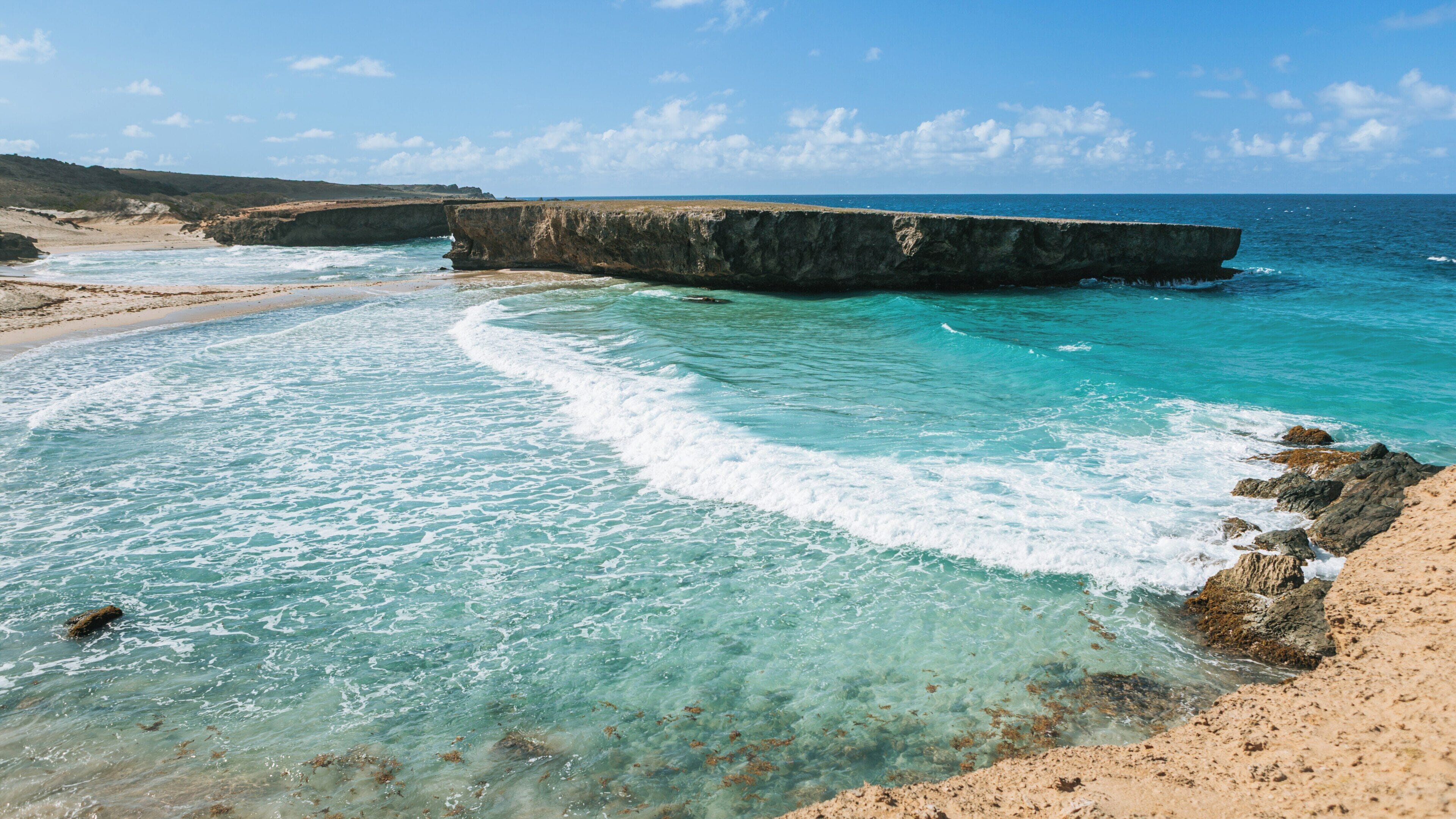 Stunning landscape of Arikok National Park showcasing the turquoise waters and unique rock formations in Santa Cruz, Aruba during a clear sunny day