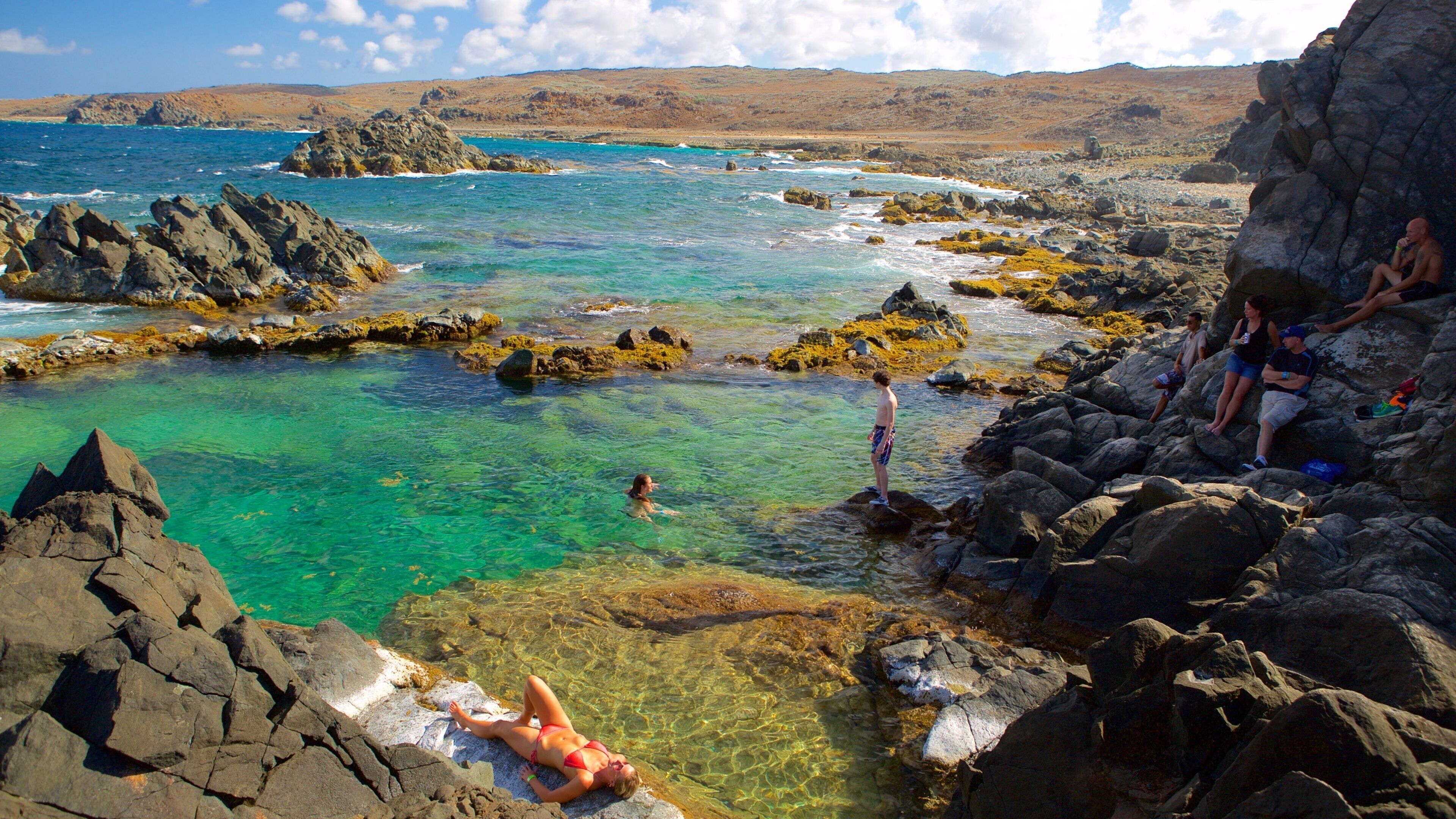 Conchi Natural Pool showing general coastal views as well as a small group of people