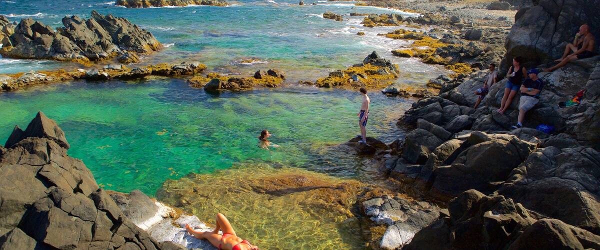 Conchi Natural Pool showing general coastal views as well as a small group of people