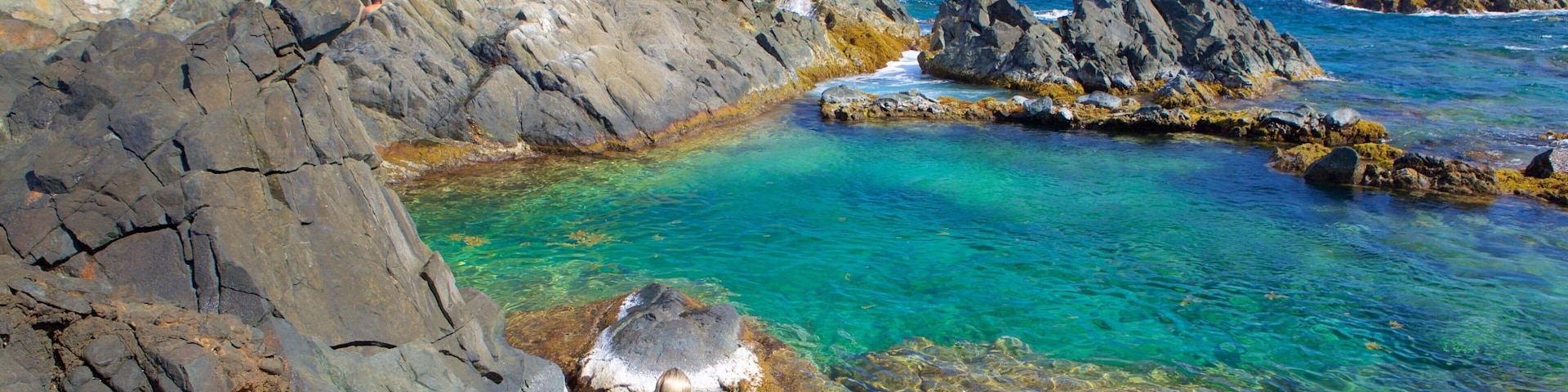 Piscina Natural de Conchi que inclui paisagens litorâneas assim como uma mulher sozinha