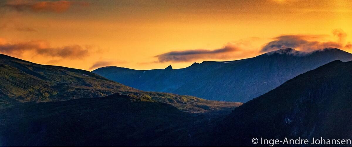 A mountainous landscape with a sunset.