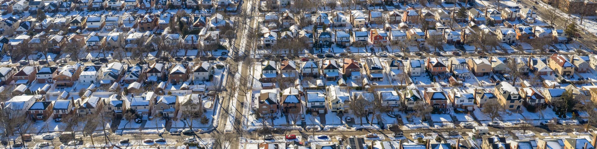 Fresh meadows queens residential neighborhood houses and streets covered in white snow and ice on a clear winter day, showing urban planning and community living in new york city