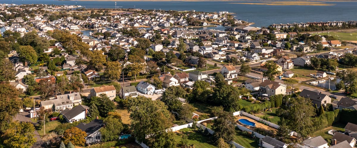 A coastal residential area with houses, a marina, and a large body of water.