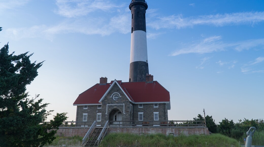 Wide establishing shot of generic lighthouse during the day time. Navigation beacon for boats heading to shore