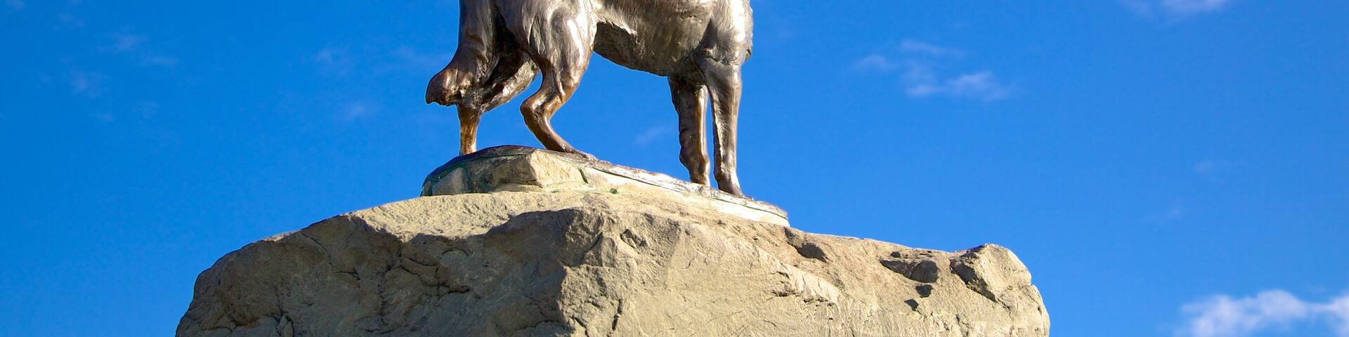 Une statue de bronze représentant un cheval, posée sur un rocher.