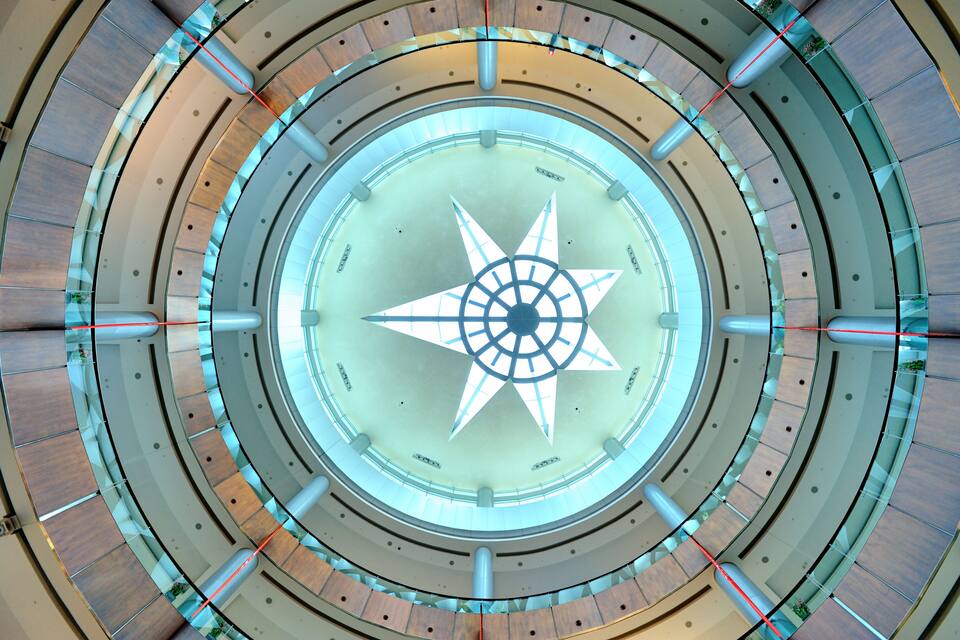 A large circular architectural structure with a central star-like design and multiple concentric rings.
