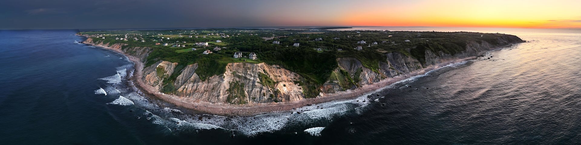 A coastal landscape with cliffs, a beach, and scattered houses.