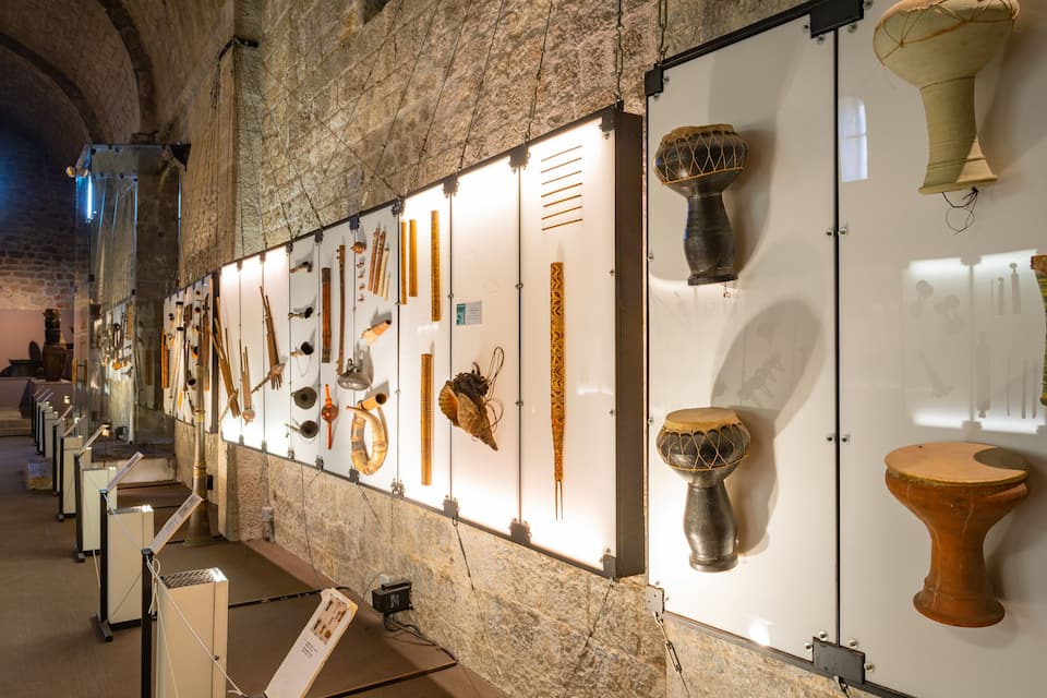 Eine Innenansicht einer Museumsausstellung mit verschiedenen antiken Artefakten in Glasvitrinen.