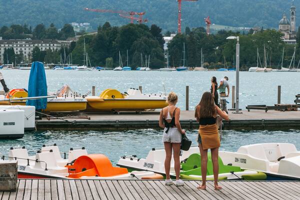 Lakeside Promenade featuring a bay or harbor as well as an individual femail
