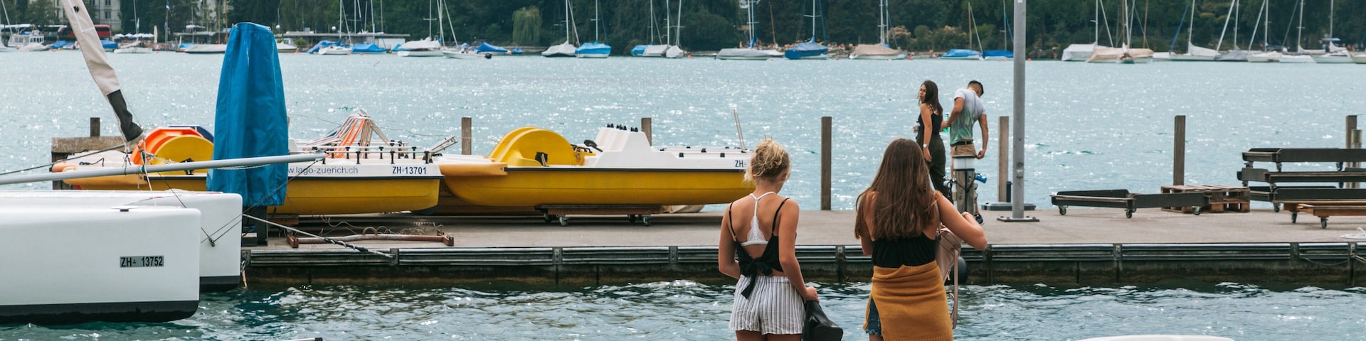 Lakeside Promenade featuring a bay or harbor as well as an individual femail