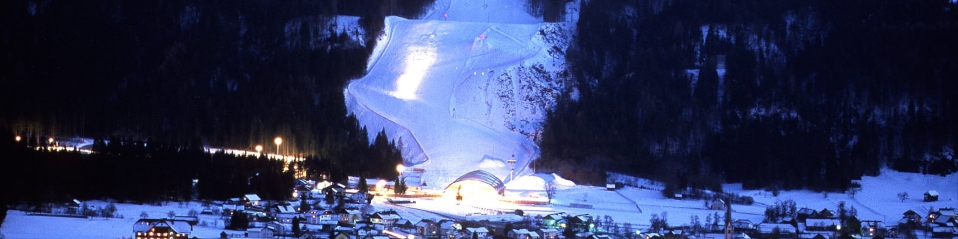 Nassfeld-Hermagor-Skigebiet mit einem bei Nacht, Kleinstadt oder Dorf und Schnee