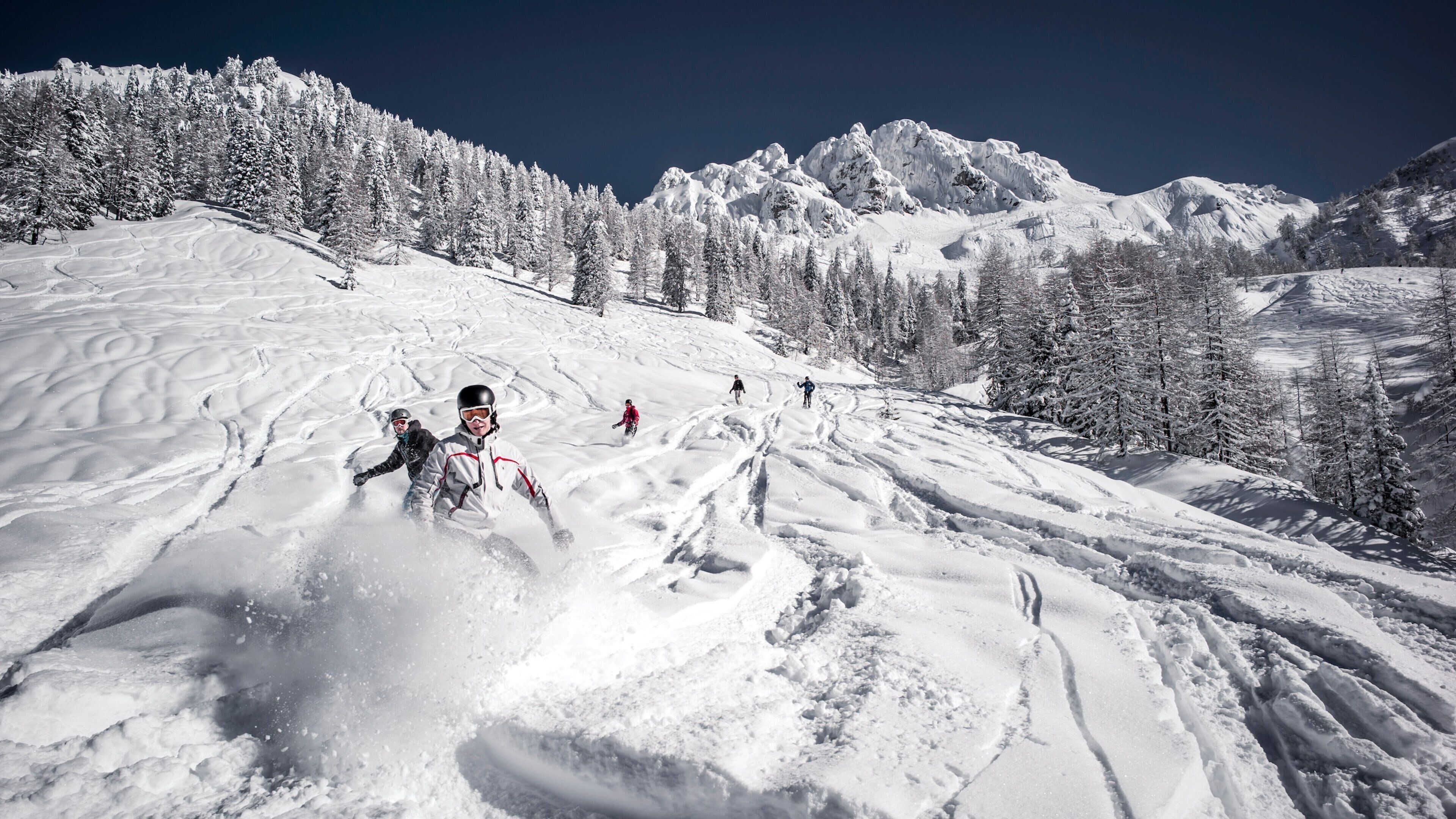 Centro de esquí Nassfeld-Hermagor mostrando nieve y montañas y también un pequeño grupo de personas