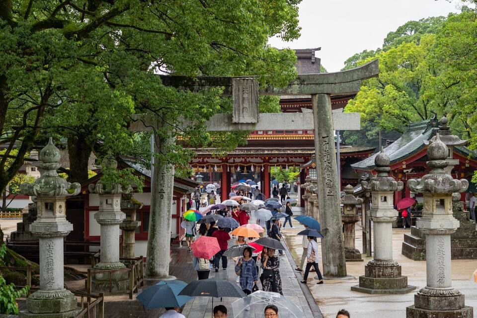 A traditional Japanese temple with stone lanterns and a red-roofed main hall.