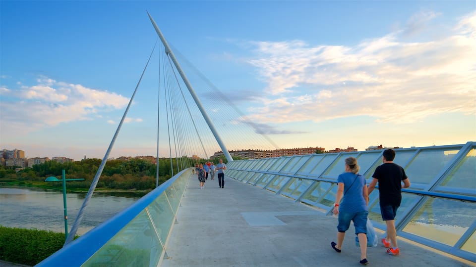 A pedestrian bridge with a glass walkway and a river below.