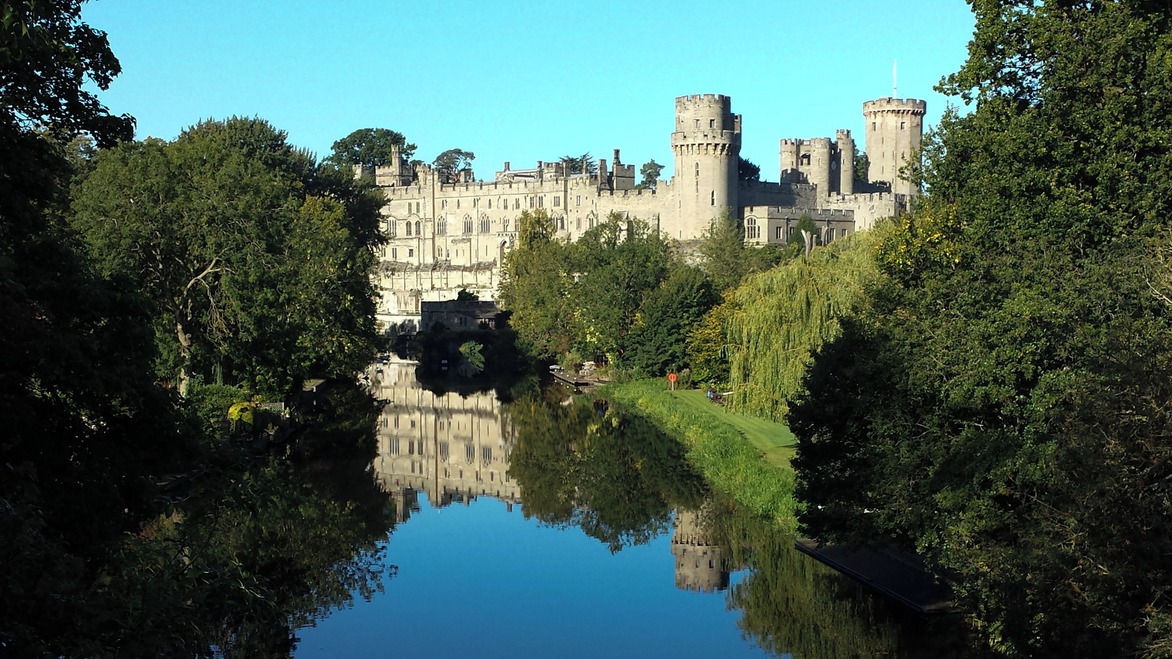 Warwick Castle from the bridge over the River Avon, Warwick, Warwickshire, UK.