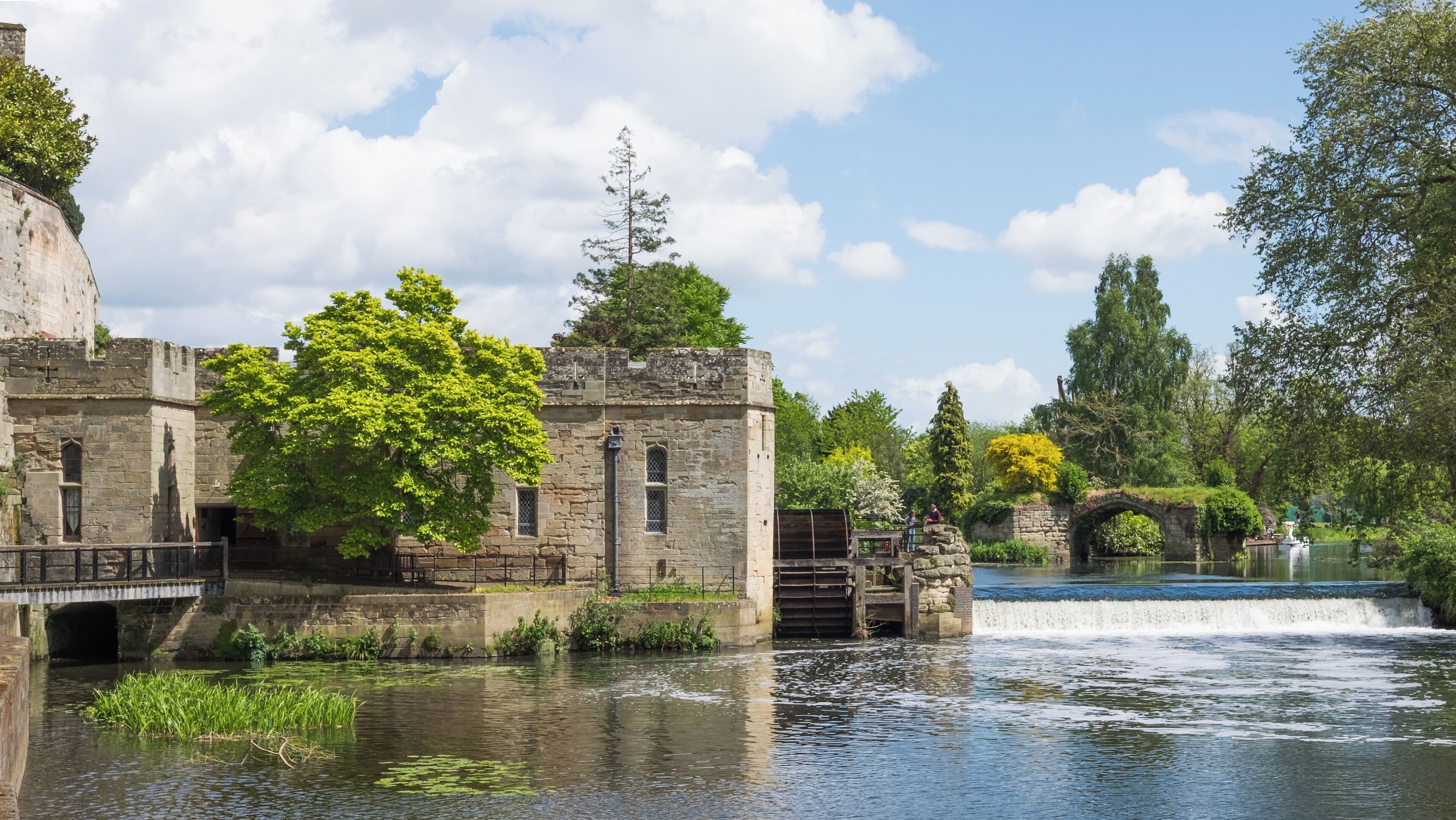 Warwick Castle engine House, waterwheel, and weir. Originally a flour mill, the building was converted to an engine room for the generation of electricity in 1894. The former mill is a grade II* listed building in England.