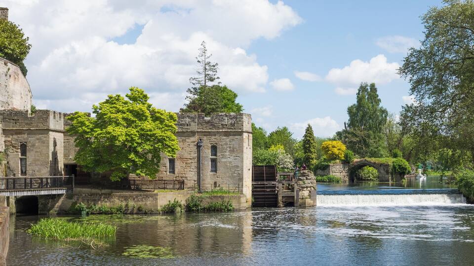 Warwick Castle engine House, waterwheel, and weir. Originally a flour mill, the building was converted to an engine room for the generation of electricity in 1894. The former mill is a grade II* listed building in England.