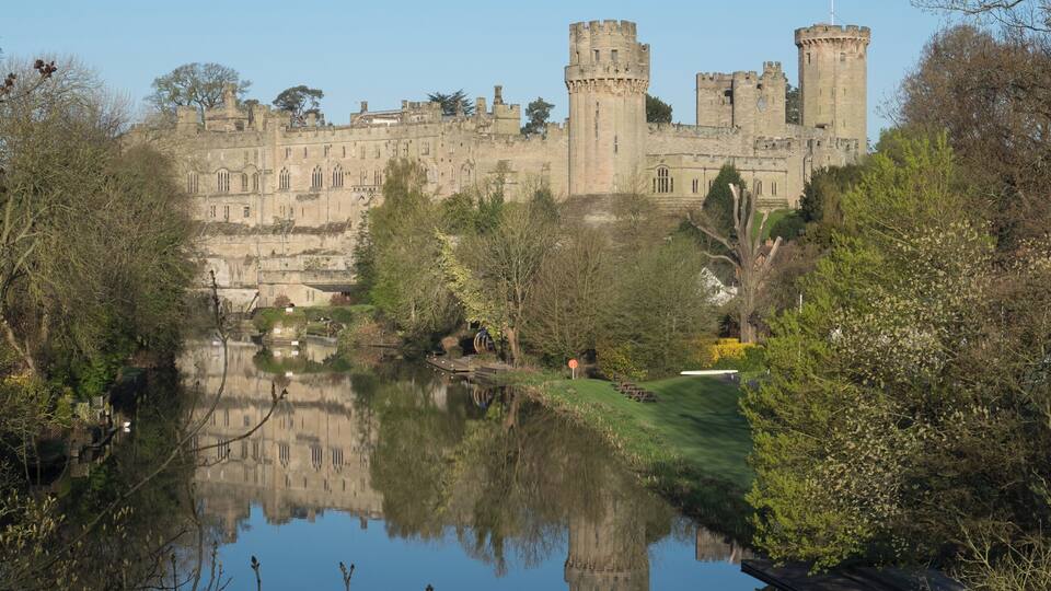 Warwick Castle from the bridge over the River Avon, Warwick, Warwickshire, UK.