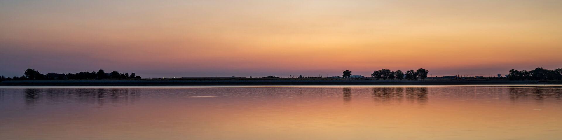 summer dawn over a calm lake - Boyd Lake State Park, popular boating and recreation area in northern Colorado