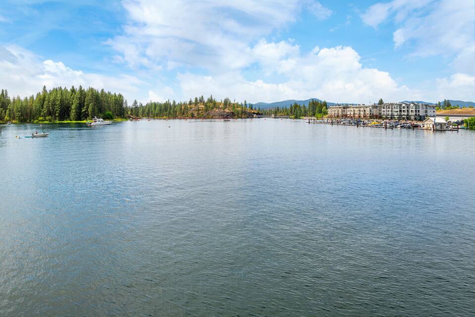 A calm lake with a dock, boats, and a forested shoreline.