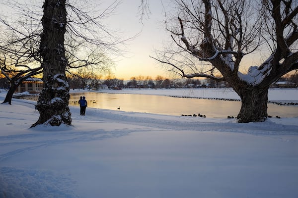 A calm and peaceful Winter scene at Washington Park in Denver, Colorado as twilight descends upon Smith Lake enveloped by the freshly fallen snow on a cold and wintry day in December.
