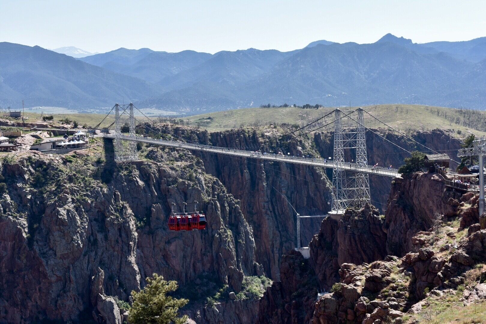 A suspension bridge over a canyon with a cable car system.