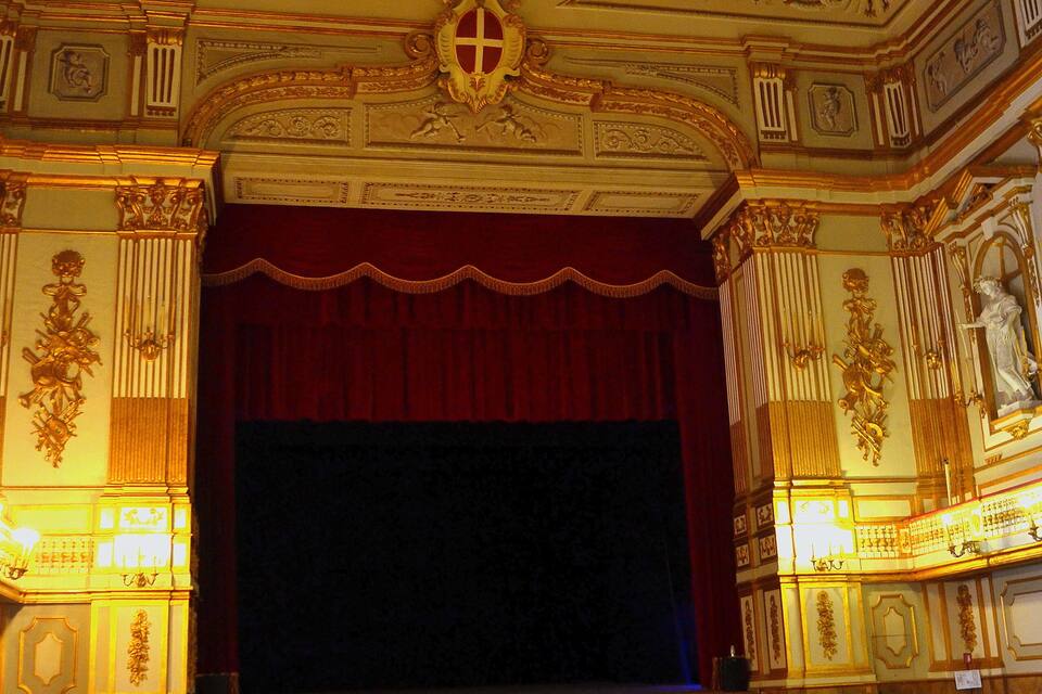 Un teatre amb seients vermells, decoracions daurades ornamentals i un gran escenari.