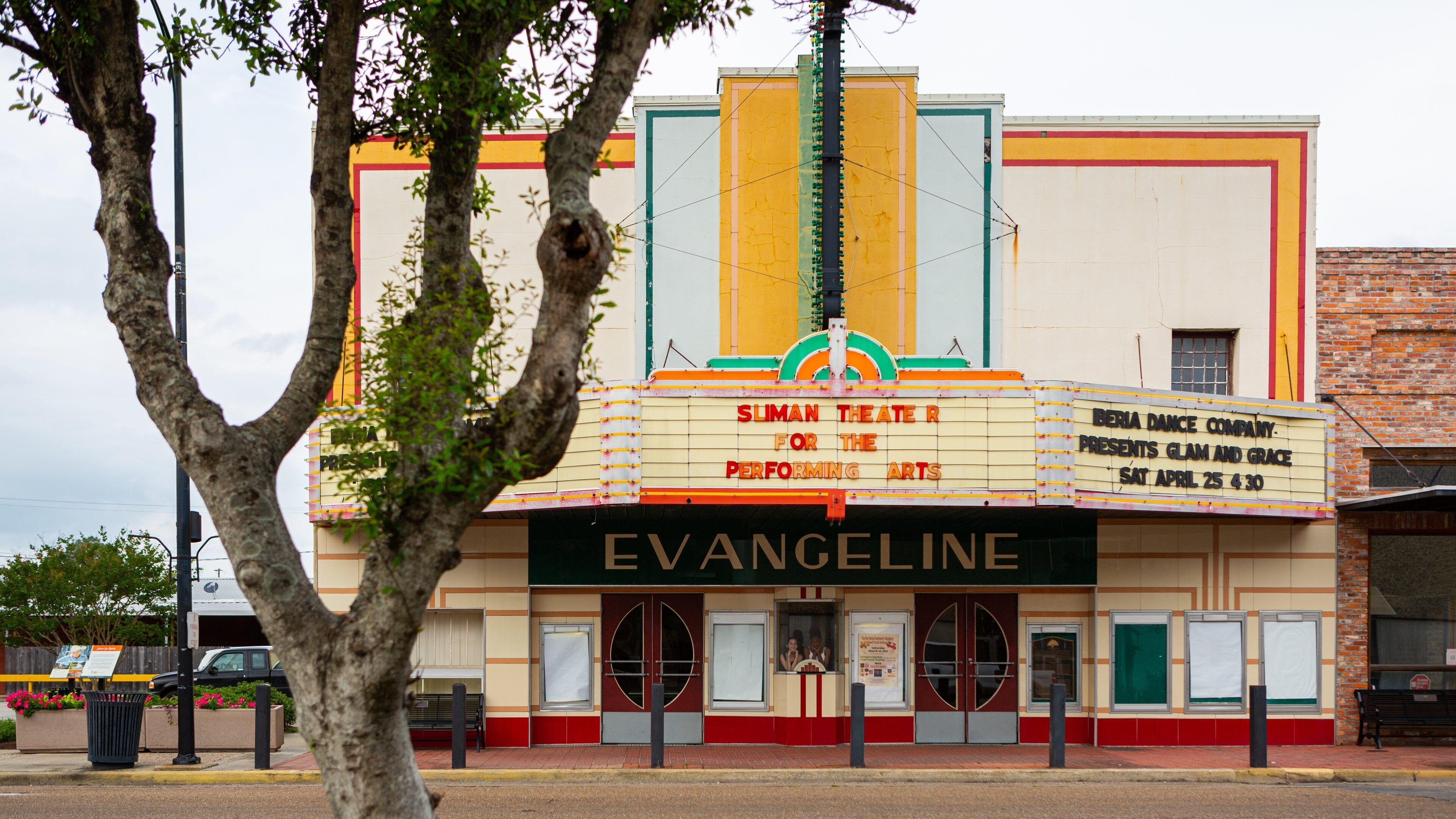 A vintage theater with a marquee advertising 'Sliman Theatre for the Performing Arts' and 'Glam and Grace' performances.