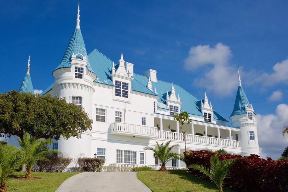A large white building with blue roofs and multiple towers.