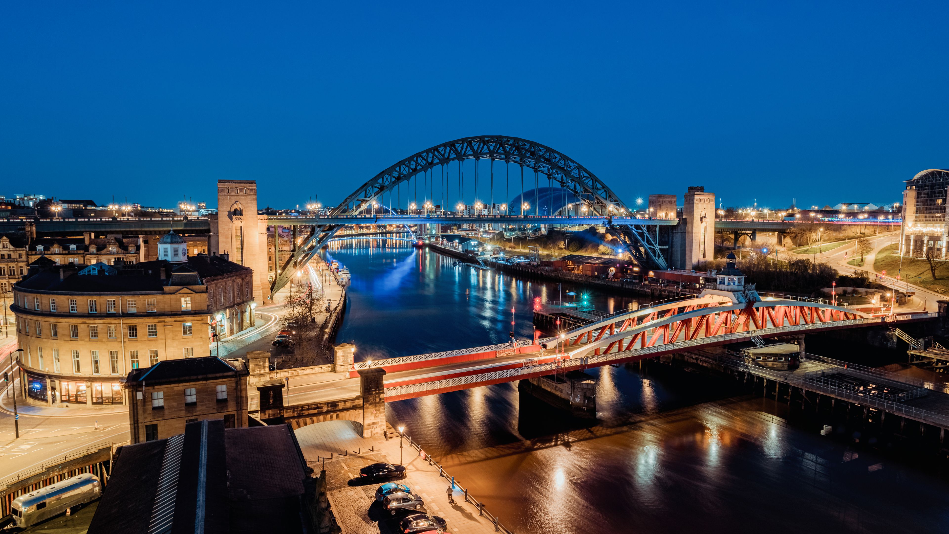 Newcastle upon Tyne UK: 30th March 2021: The iconic Newcastle Gateshead skyline Quayside at night, with of Tyne Bridge and city skyline, long exposure during blue hour